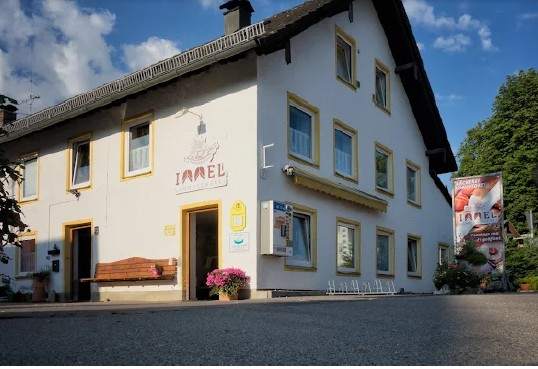 Immel Hurlach, Gründungshaus mit Bank und Blumen vor der Tür